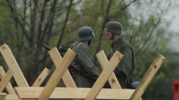 2 Wehrmachtští vojáci v německých armádních uniformách spolu hovoří na stráži, ve službě během rekonstrukce invaze do SSSR 22. června1941. Druhá světová válka. BOBRUISK, BELARUS, 9. května 2021 — Stock video