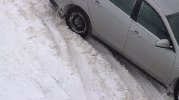 Το αυτοκίνητο γλιστρά στο χιόνι κάτω από το οποίο υπάρχει πάγος στο δρόμο το χειμώνα. Σοβαρή χιονοθύελλα, χιονοστιβάδα — Αρχείο Βίντεο