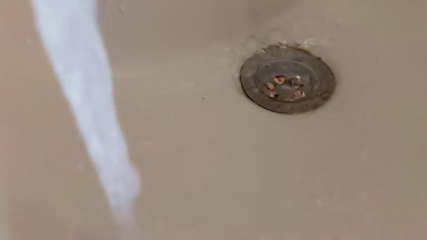 Musluktan lavaboya ve gidere su akıyor. Kanalizasyon ve su tüketimi hizmetleri için ödeme kavramı, yavaş çekim — Stok video