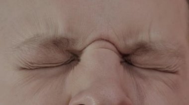 Beyaz bir adam gözlerini kapar ve göz kapaklarını açar, makro. Görsel