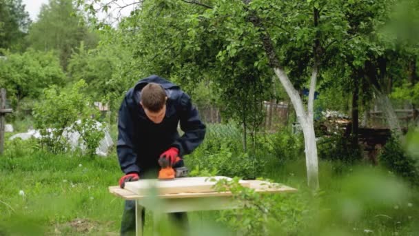 En man polerar trä med ett elverktyg, en närbild. Handgjort trä, rengör trä med sandpapper — Stockvideo