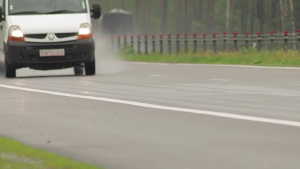 Road Bobruisk-Minsk, Belgien - 19 maj 2021: Trafik från bilar och lastbilar färdas på motorvägen med strålkastare tända när det regnar — Stockvideo