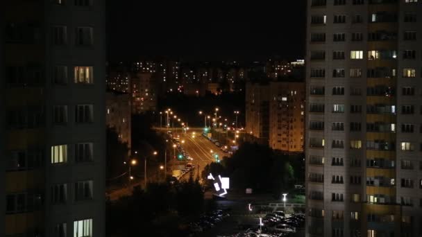 Night city in lights. Lights in the windows of houses, lights from car headlights and lights on the street — Stock Video