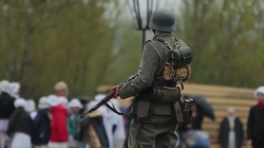 2. Dünya Savaşı sırasında Alman ordusunun Wehrmacht üniformalı sakallı askeri, 22 Haziran 1941 'de Sovyetler Birliği' nde işgalin yeniden inşası sırasında tüfekli, ayakta ve yürüyordu.