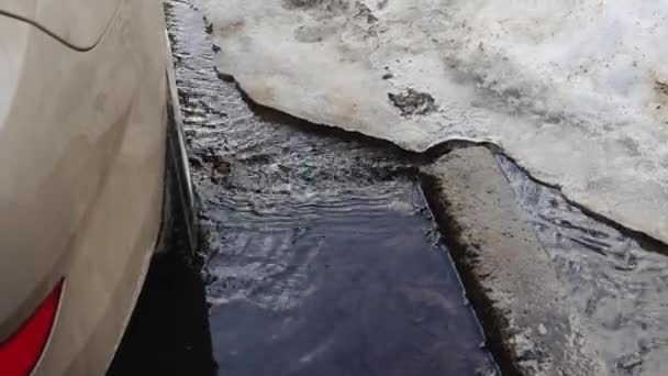 Melting snow in the spring in the city. Streams of water flow through the city. The beginning of spring, background — Stock Video