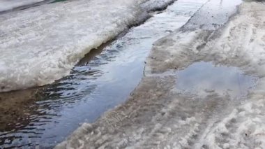 Şehirde ilkbaharda eriyen karlar. Şehrin içinden akan su akıntıları. Baharın başlangıcı, arka plan