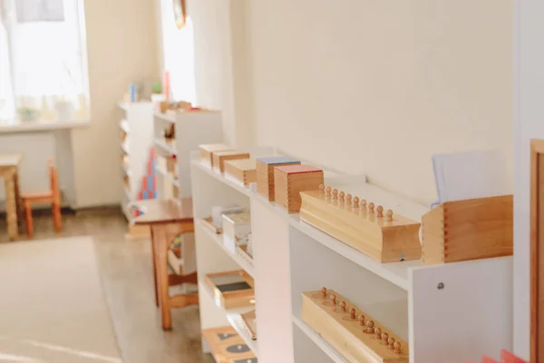 Montessori çalışmaları için malzeme dolu ahşap bir raf. Matematik eğitimi.