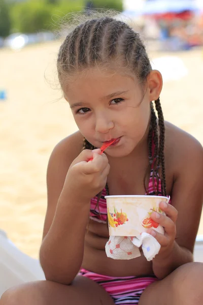 Menina comendo sorvete na praia — Fotografia de Stock