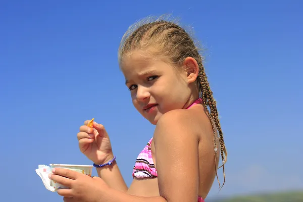 Petite fille manger de la crème glacée sur la plage — Photo