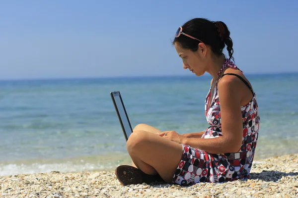Femme avec ordinateur portable sur la plage Image En Vente
