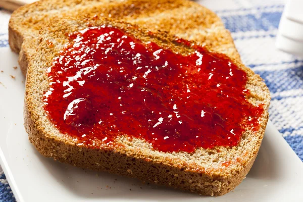 Домашнее органическое красное клубничное желе на тосте — стоковое фото
