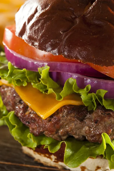 Gastronomische kaas hamburger op een broodje krakeling — Stockfoto