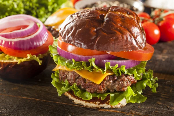 Gourmet ost hamburgare på en kringla rulle — Stockfoto