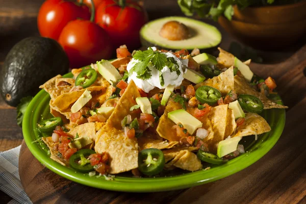 Zelfgemaakte ongezonde nachos met kaas en groenten — Stockfoto