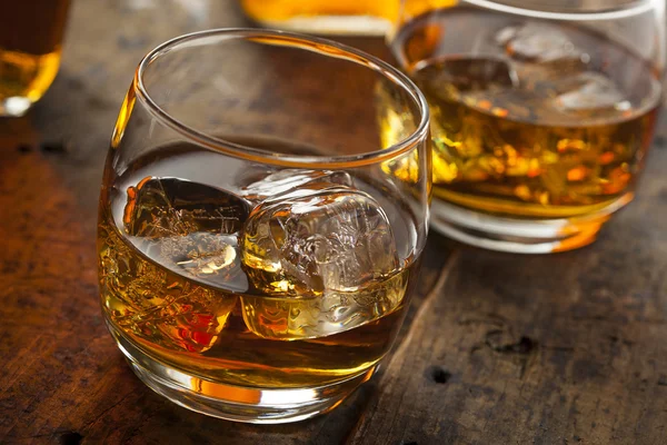 Bourbon de whisky alcohólico en un vaso con hielo — Foto de Stock