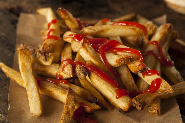 Papas fritas caseras cubiertas de ketchup — Foto de Stock