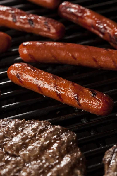 Hamburgery i hot dogi na grill — Zdjęcie stockowe