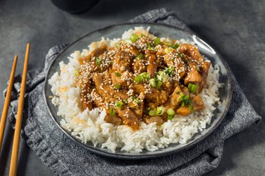 Ev yapımı Asya sarımsaklı zencefilli domuz eti, pilav ve susamlı.