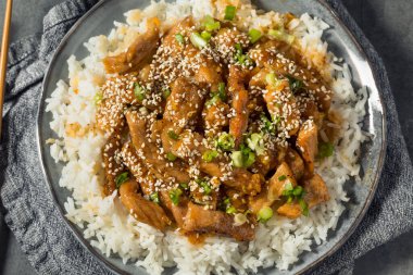 Ev yapımı Asya sarımsaklı zencefilli domuz eti, pilav ve susamlı.