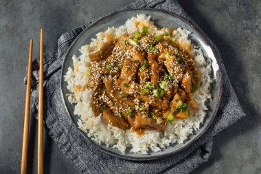 Ev yapımı Asya sarımsaklı zencefilli domuz eti, pilav ve susamlı.