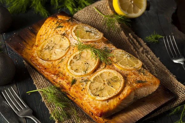 Salmón a la parrilla hecho en casa en un tablón de cedro —  Fotos de Stock