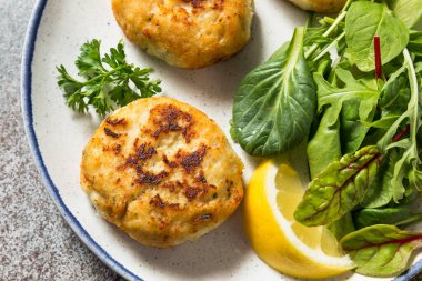 Salata ve Tatar soslu ev yapımı kızarmış yengeç kekleri.