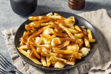 Ev yapımı peynirli poutine soslu ve peynirli patates kızartması.