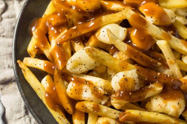 Ev yapımı peynirli poutine soslu ve peynirli patates kızartması.