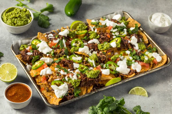 Homemade Mexican Shredded Beef Nachos with Gaucamole and Sour Cream