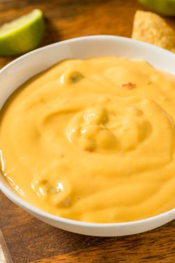 Homemade Yellow Queso Cheese Dip with Tortilla Chips and Lime