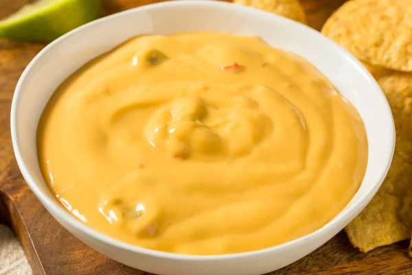 Homemade Yellow Queso Cheese Dip with Tortilla Chips and Lime