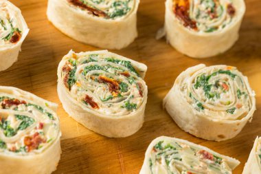 Krem peynirli ve ıspanaklı ev yapımı fırıldak tortilla aperatifleri.