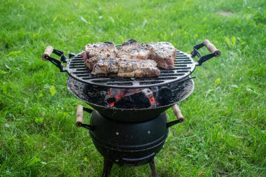 Et parçaları eski ızgarada kızarıyor.