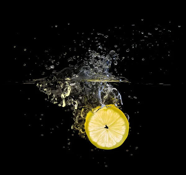 Fresh lemon slice splash on black — Stock Photo, Image