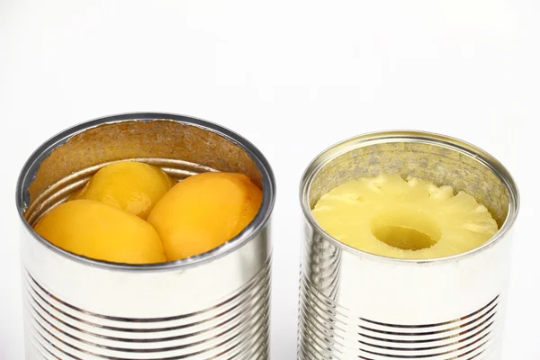 The tins with peaches and pineapples — Stock Photo, Image