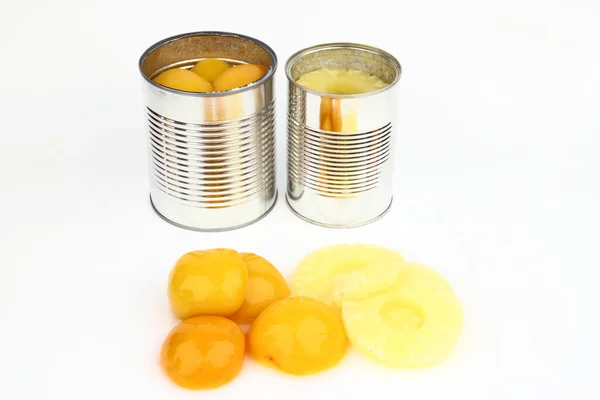 The tins with peaches and pineapples — Stock Photo, Image