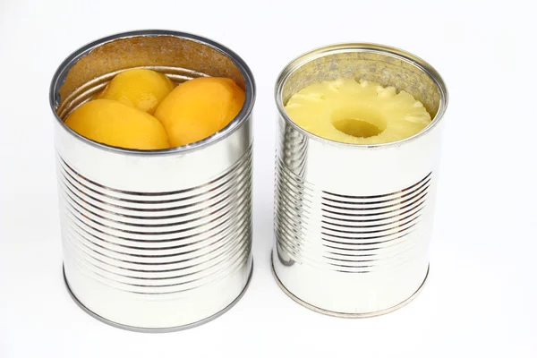 The tins with peaches and pineapples Royalty Free Stock Images