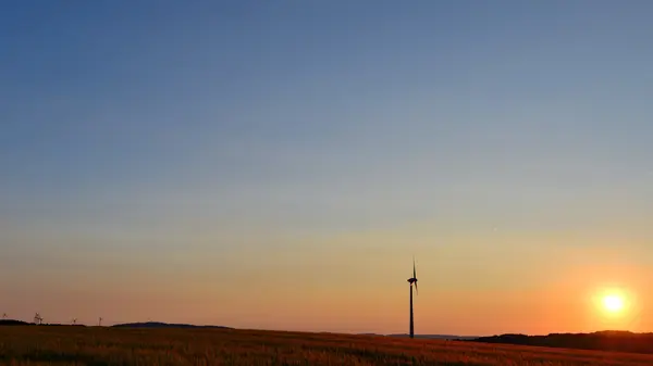 Vindmøller på et jorde ved solnedgang – stockfoto