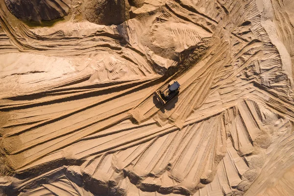 Buldozer kumlu bir taş ocağında kum kazıyor. Ağır makinelerle kum ocağı çalışma sürecinde