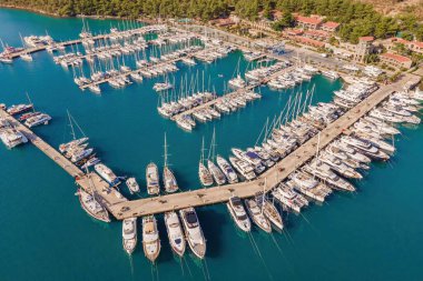 Marmaris, Türkiye 'de tekne ve yatlarla dolu bir liman. Lüks tekneler rıhtıma demirlemiş, tatil köyünün yakınındaki dalgalarda yavaşça sallanıyorlar..