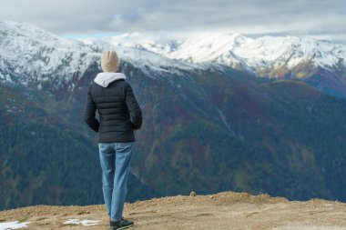 Dağın tepesindeki genç bayanın arka manzarası