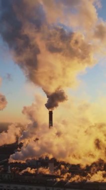 Atmosferde dumanlı karbon gazlarının endüstriyel fabrika emisyonları. Dumanla kirlenmiş endüstriyel borular. Dikey video