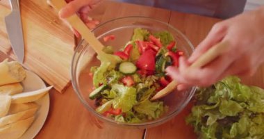 Modern mutfakta organik salata için sebze hazırlayan bir kadın. Sağlıklı beslenme ve yaşam tarzı kavramı