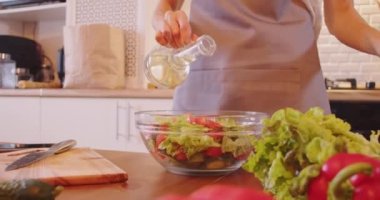 Modern mutfakta organik salata için sebze hazırlayan bir kadın. Sağlıklı beslenme ve yaşam tarzı kavramı