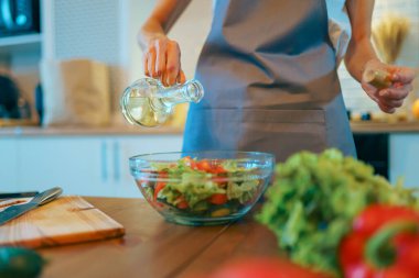 Sebze pişiren kadın, modern mutfakta sağlıklı yemek pişiren vejetaryen.