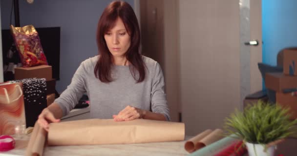 A embrulhar o presente do Dia da Santidade. Mulher Mãos decorando presente elegante em papel artesanal — Vídeo de Stock