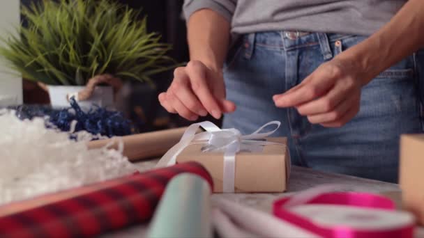 Женские руки обертывание праздничных подарков праздничной лентой — стоковое видео