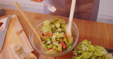 Kadın modern mutfakta organik salata için sebze hazırlıyor.