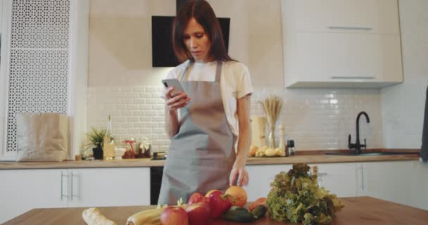 Vrouw controleren vers fruit met recepe het in smartphone — Stockvideo