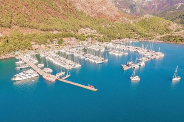 Marmaris, Türkiye 'de tekne ve yatlarla dolu bir liman. Lüks tekneler rıhtıma demirlemiş, tatil köyünün yakınındaki dalgalarda yavaşça sallanıyorlar..